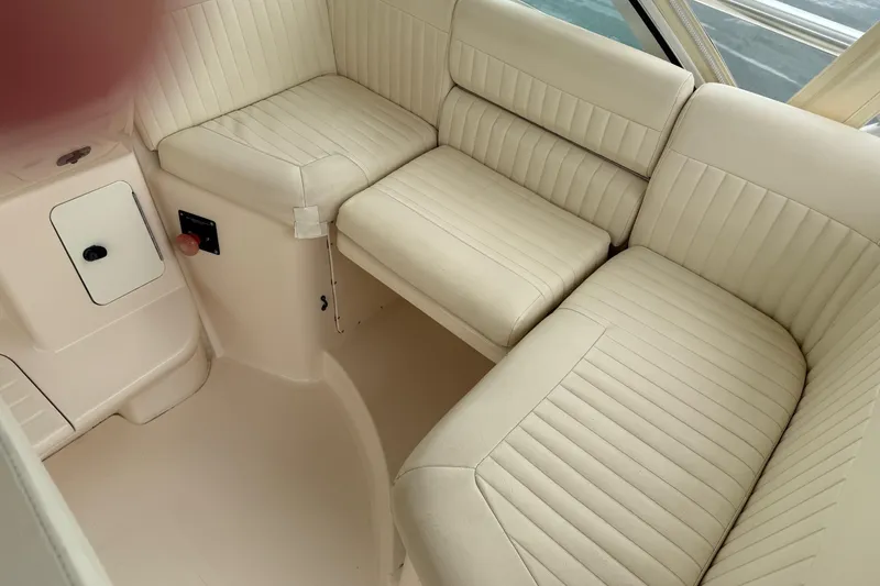 Slide: The Image of 2008 Grady-White Express 360 interior seating with cream upholstery and storage compartment. - 9
