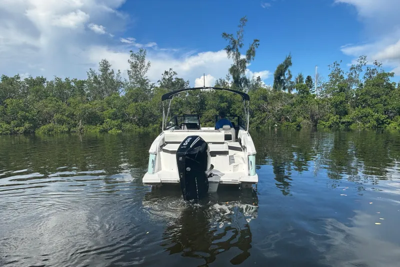 Slide: The Image of 2025 Cobalt R4 Outboard boat on calm water, surrounded by lush greenery. - 2