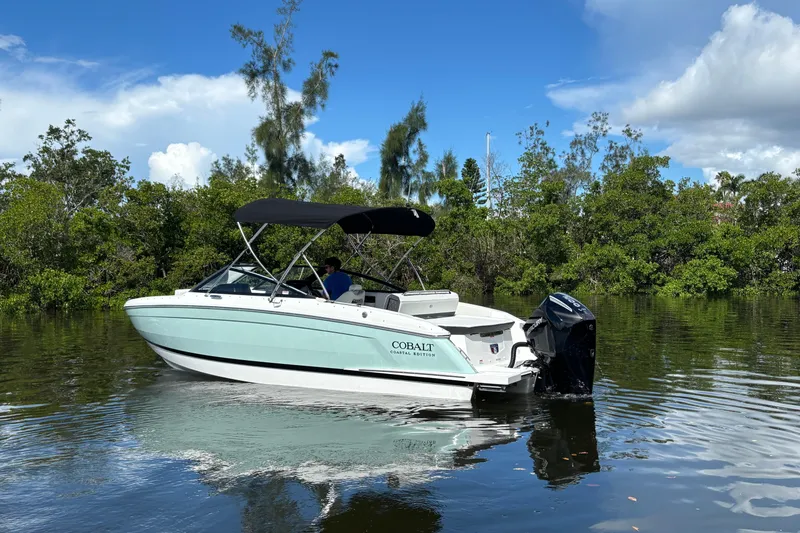 Slide: The Image of 2025 Cobalt R4 Outboard boat on calm water, surrounded by lush greenery. - 3