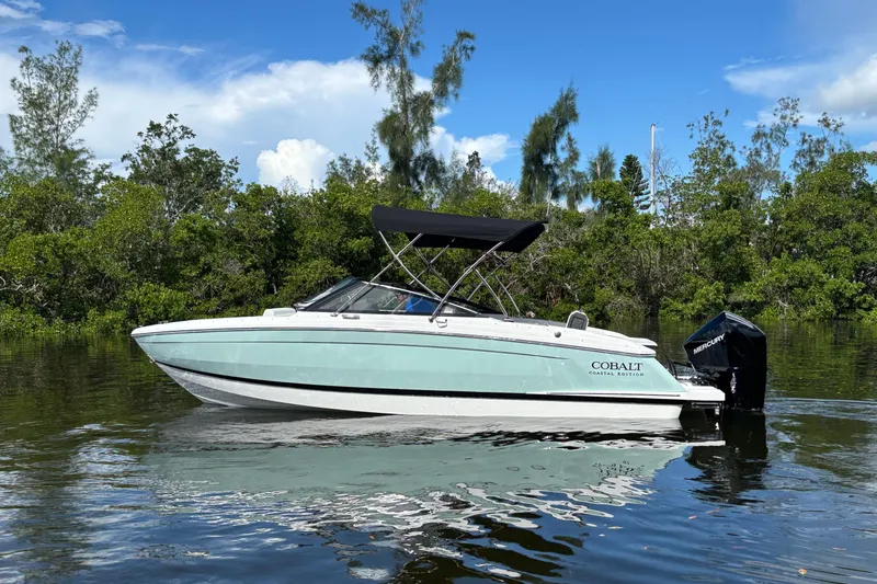 Slide: The Image of 2025 Cobalt R4 Outboard boat on a serene waterway, surrounded by lush greenery. - 4