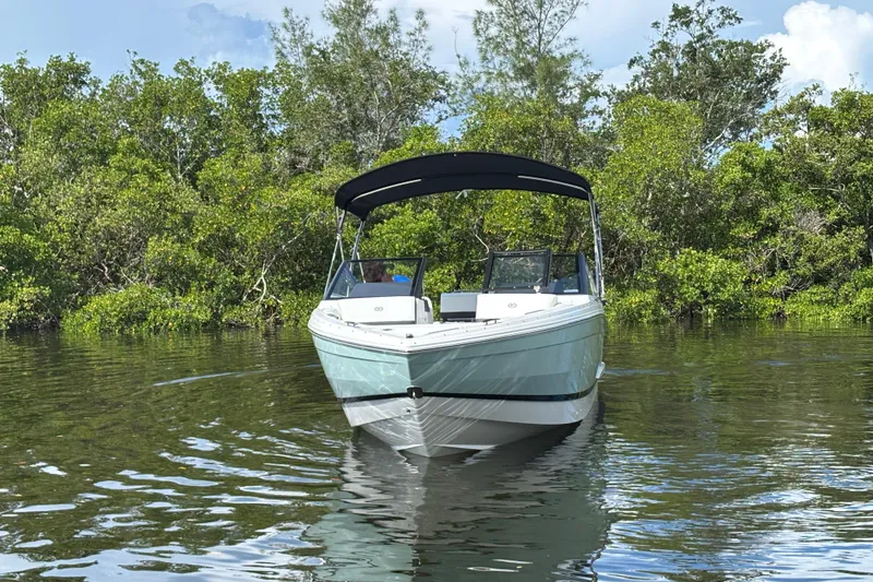 Slide: The Image of 2025 Cobalt R4 Outboard boat on calm water, surrounded by lush greenery. - 5