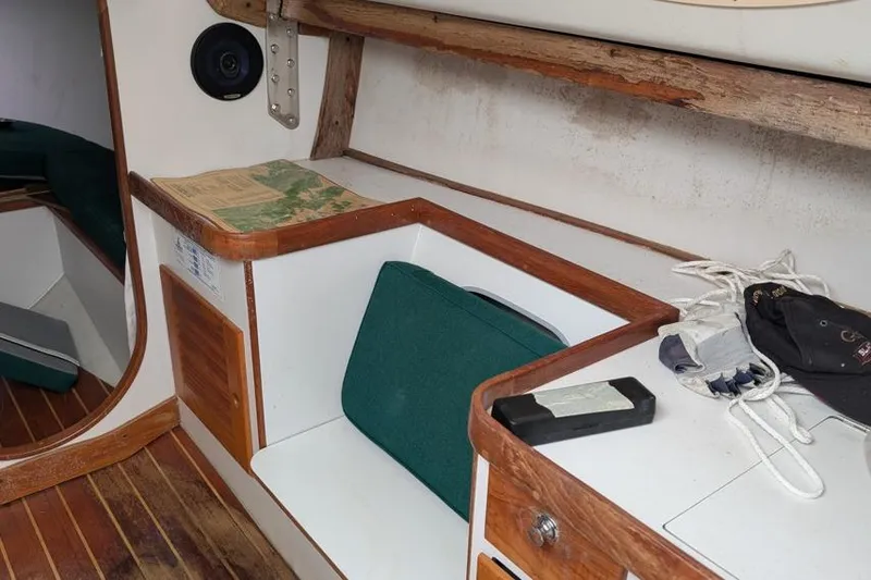 Slide: The Image of Interior of a 2001 Alerion 28 sailboat with wooden trim and green cushions. - 4