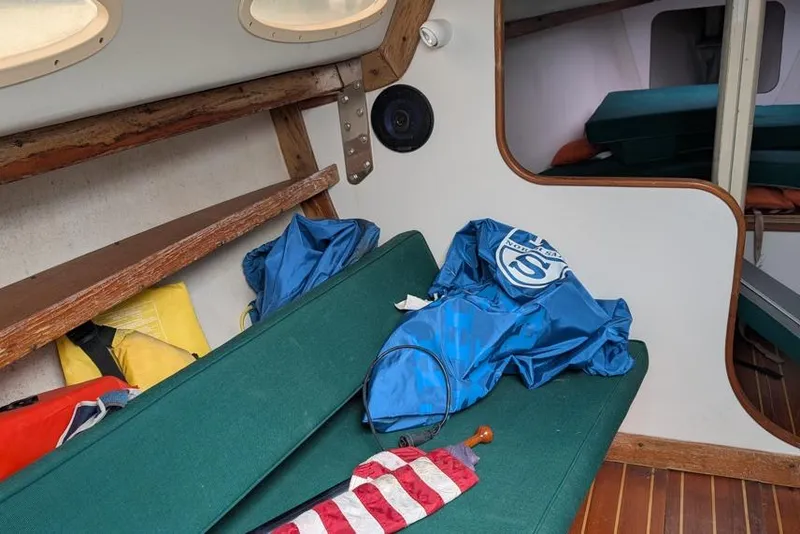 Slide: The Image of Interior of a 2001 Alerion 28 sailboat with green seating and nautical gear. - 5