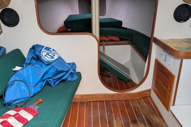 Slide: The Image of Interior of a 2001 Alerion 28 sailboat with green cushions and wooden flooring. - 6