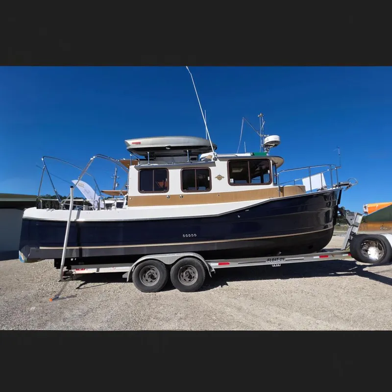 The Image of 2013 Ranger Tugs R27 Classic boat on trailer, side view, under clear blue sky. - 0