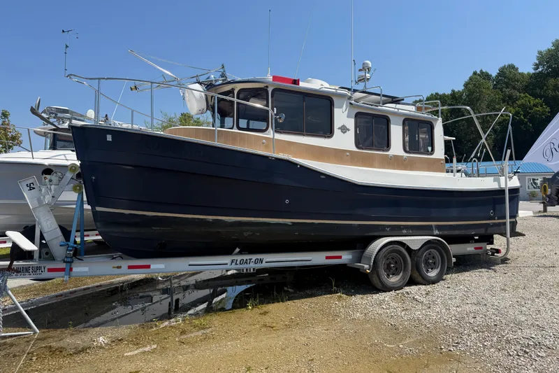 Slide: The Image of 2013 Ranger Tugs R27 Classic boat on trailer under clear blue sky. - 1