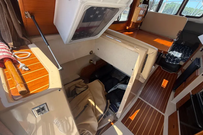 Slide: The Image of 2013 Ranger Tugs R27 Classic interior with wood finish, kitchenette, and helm station. - 19