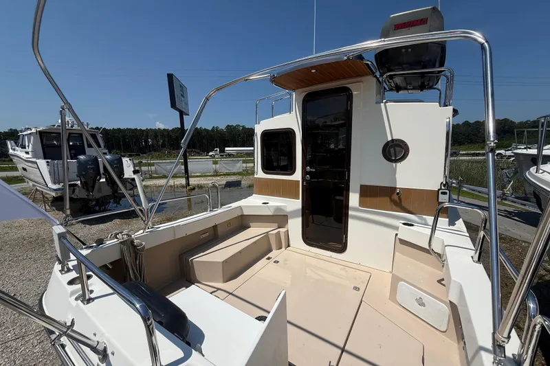 Slide: The Image of 2013 Ranger Tugs R27 Classic boat deck with wooden table and nautical design. - 5