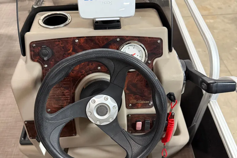 Slide: The Image of 2021 Sun Tracker Bass Buggy 16 XL steering console with wood panel and gauge. - 10