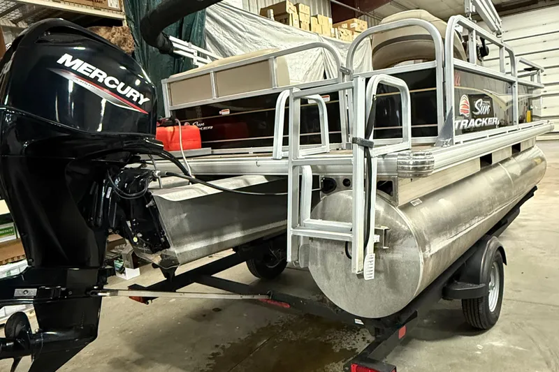 Slide: The Image of 2021 Sun Tracker Bass Buggy 16 XL pontoon boat with Mercury outboard motor in a garage. - 4