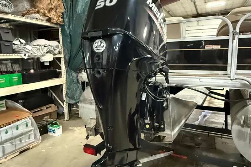 Slide: The Image of 2021 Sun Tracker Bass Buggy 16 XL with Mercury outboard motor in a storage area. - 5