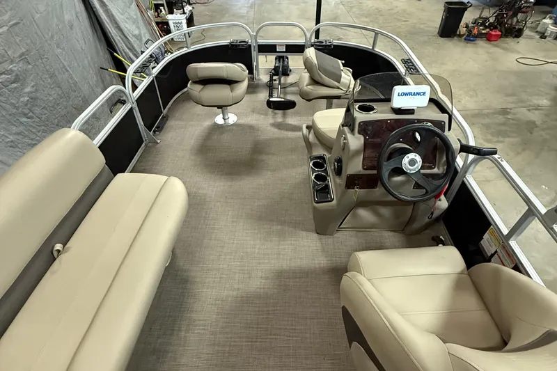 Slide: The Image of 2021 Sun Tracker Bass Buggy 16 XL pontoon boat interior with beige seating and steering console. - 9