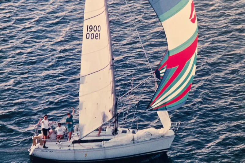 The Image of 1985 Beneteau First 29 sailboat with colorful spinnaker on open water. - 0