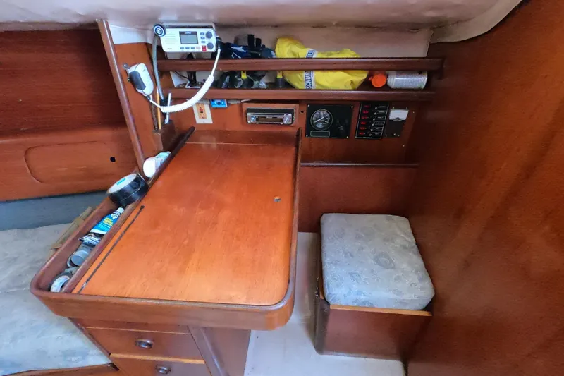 Slide: The Image of 1985 Beneteau First 29 yacht interior with navigation station and wooden cabinetry. - 11