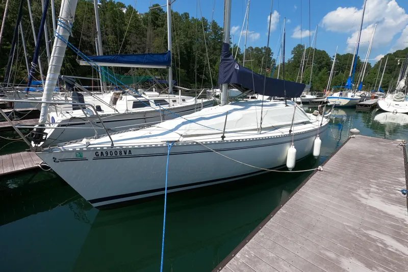 Slide: The Image of 1985 Beneteau First 29 sailboat docked in a marina, surrounded by other boats. - 2