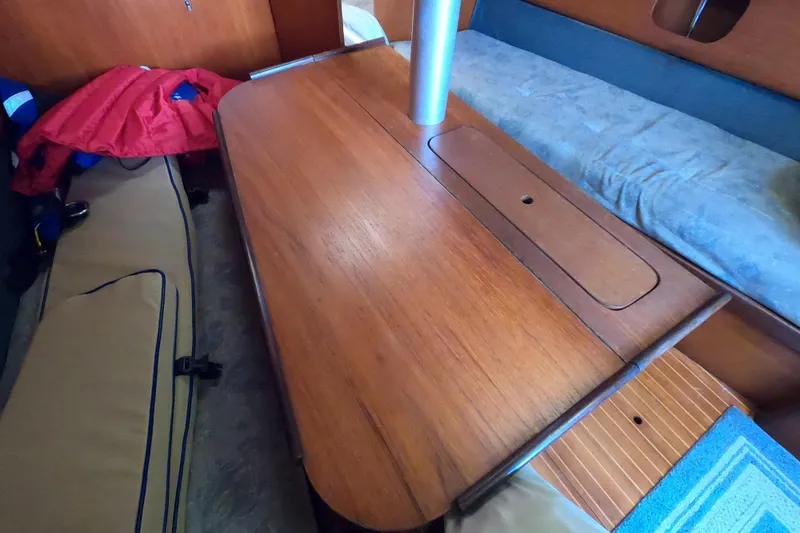 Slide: The Image of Interior of 1985 Beneteau First 29 sailboat with wooden table and seating area. - 20