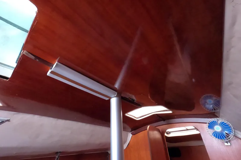 Slide: The Image of Interior view of 1985 Beneteau First 29 sailboat with wooden ceiling and small fan. - 24