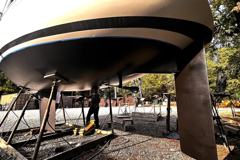 Slide: The Image of 1985 Beneteau First 29 sailboat under maintenance, hull view, outdoor setting. - 25