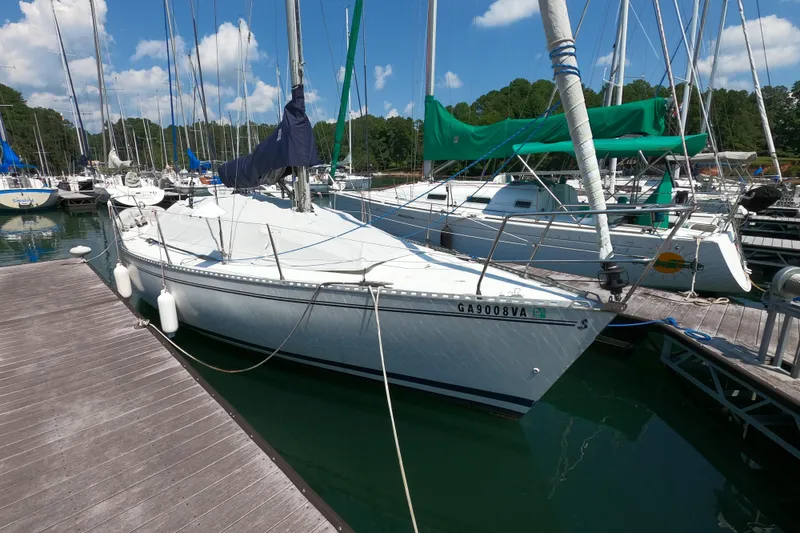 Slide: The Image of 1985 Beneteau First 29 sailboat docked at marina, surrounded by other boats. - 3