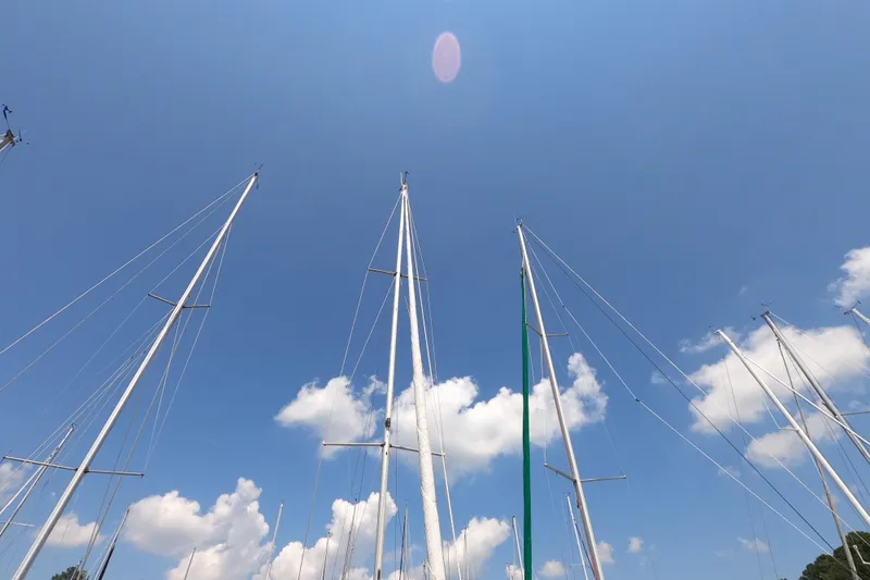 Slide: The Image of Sailboat masts against a clear blue sky, Beneteau First 29, 1985 model. - 6