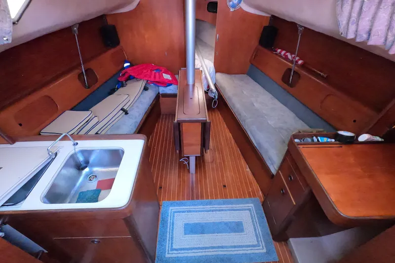 Slide: The Image of Interior of 1985 Beneteau First 29 sailboat with wooden furnishings and compact layout. - 9