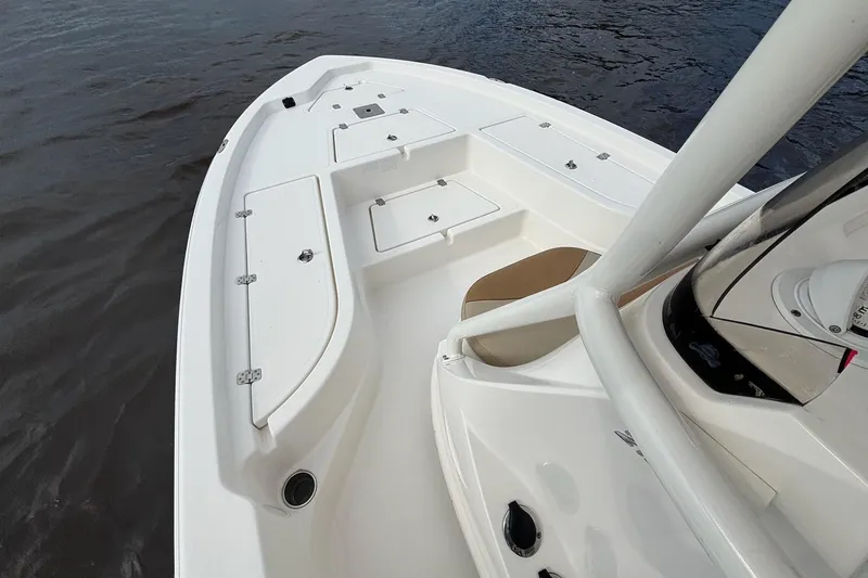 Slide: The Image of 2023 NauticStar 215XTS boat deck with storage compartments on calm water. - 2