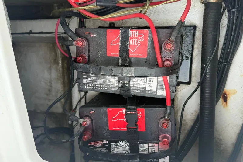 Slide: The Image of Batteries in a 2013 Sea Hunt Triton 210 boat, secured with red cables. - 11