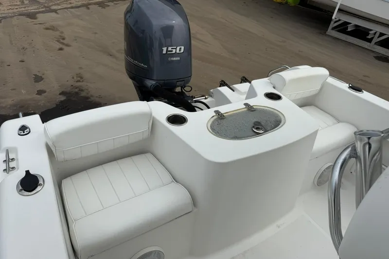 Slide: The Image of 2013 Sea Hunt Triton 210 boat with Yamaha 150 engine, featuring white seating and storage. - 14