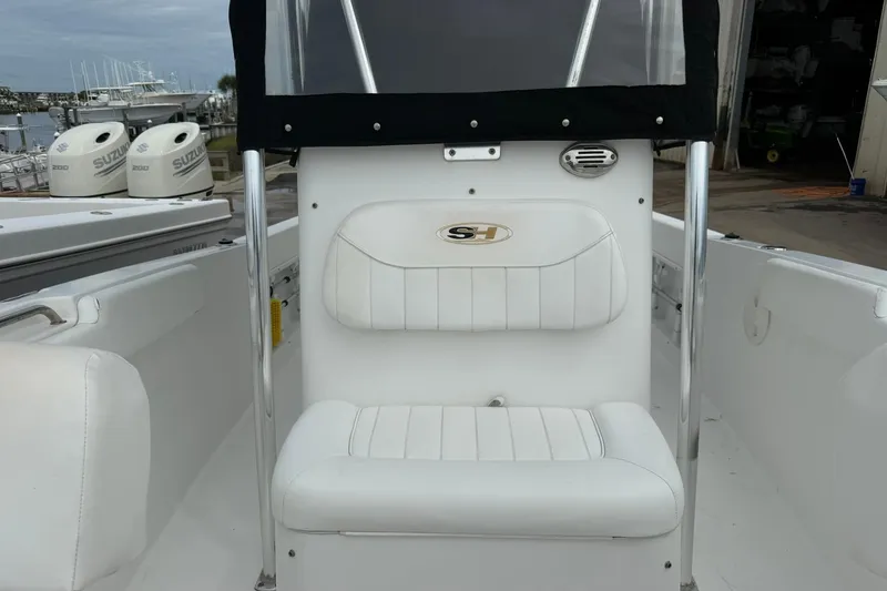 Slide: The Image of 2013 Sea Hunt Triton 210 boat interior with white seating and Suzuki engines in background. - 17
