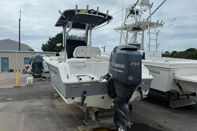 Slide: The Image of 2013 Sea Hunt Triton 210 boat with Yamaha 150 engine, docked outdoors. - 3