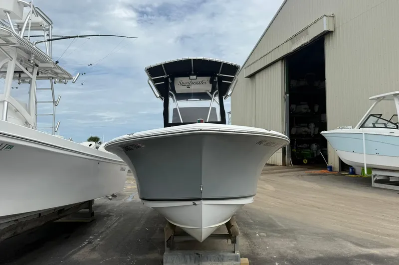 Slide: The Image of 2013 Sea Hunt Triton 210 boat in a marina, front view, with overcast sky. - 4