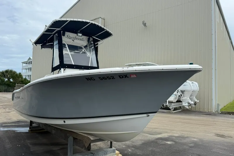 Slide: The Image of 2013 Sea Hunt Triton 210 boat docked near a large building. - 6