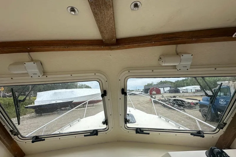 Slide: The Image of Interior view from a 2013 Eastern Explorer 248 boat, showing docked vessels and a truck outside. - 13