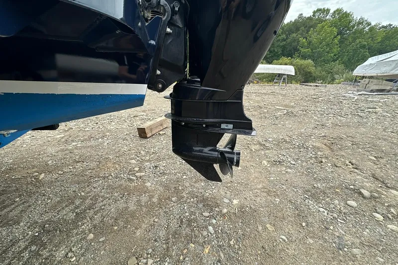 Slide: The Image of 2013 Eastern Explorer 248 boat motor on rocky ground, showcasing propeller and hull details. - 23