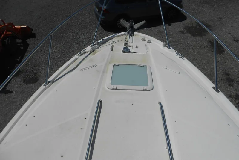 Slide: The Image of 2008 Bayliner 300 boat deck with hatch and railing, parked on gravel. - 10