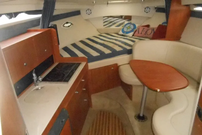 Slide: The Image of Interior of a 2008 Bayliner 300 boat with kitchenette and seating area. - 12