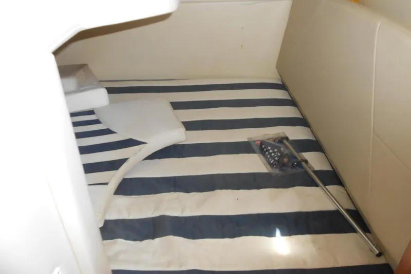 Slide: The Image of Interior cabin of 2008 Bayliner 300 with striped bedding and accessories. - 14