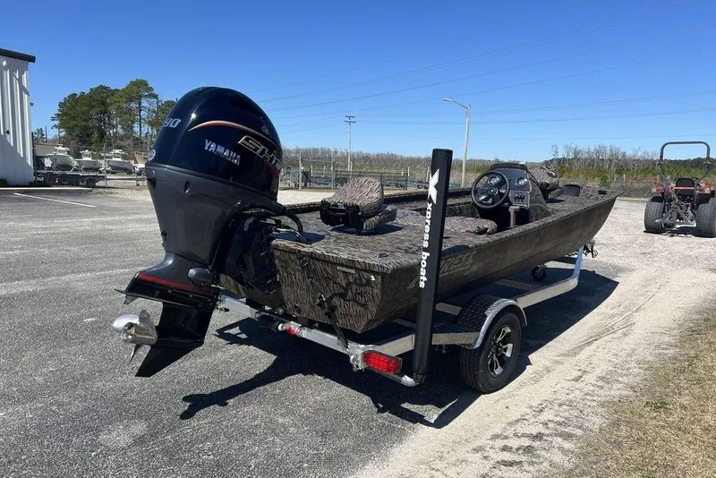 Slide: The Image of 2025 Xpress XP180 boat with Yamaha engine on trailer, parked outdoors. - 4