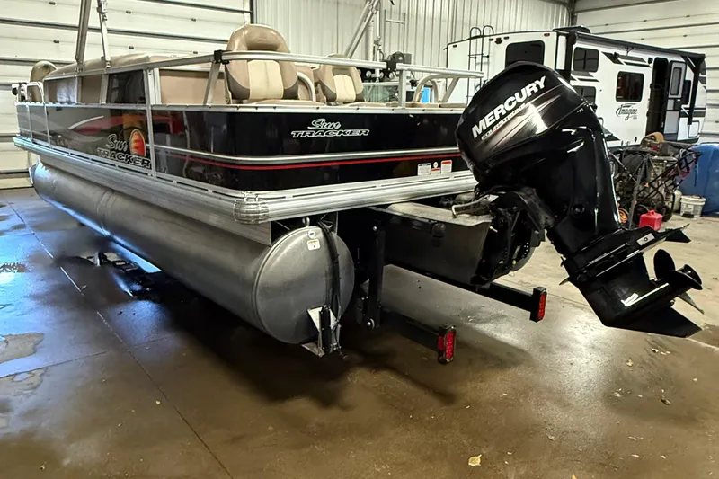 Slide: The Image of 2014 Sun Tracker Fishin' Barge 20 DLX pontoon boat with Mercury outboard motor in a garage. - 3