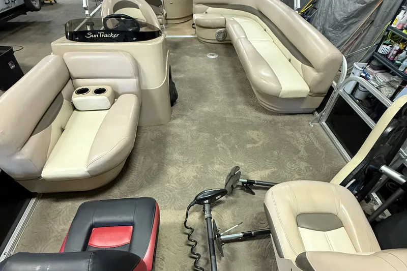 Slide: The Image of 2014 Sun Tracker Fishin' Barge 20 DLX interior with beige seating and steering console. - 9