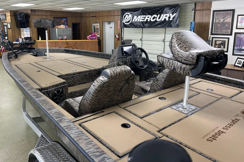 Slide: The Image of 2026 Xpress H20 Bass boat interior with camo seats and Mercury banner. - 3