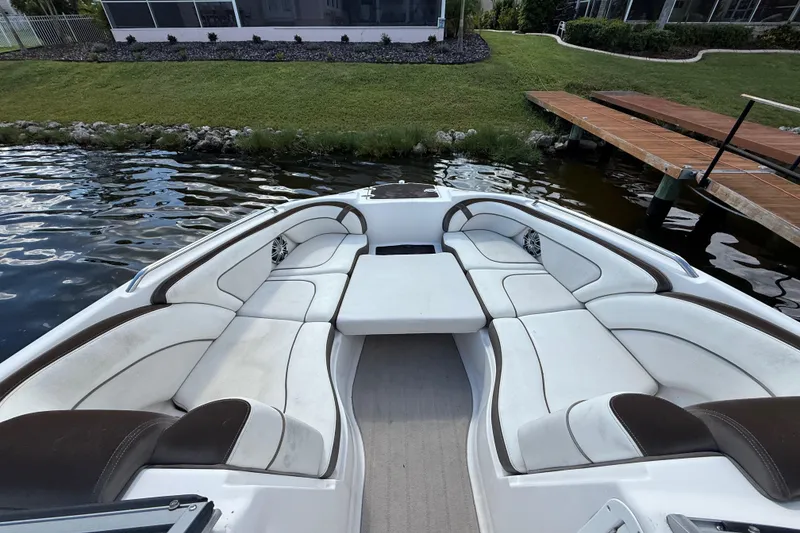 Slide: The Image of 2014 Yamaha Boats 242 Limited S interior with white seating, dockside view. - 27