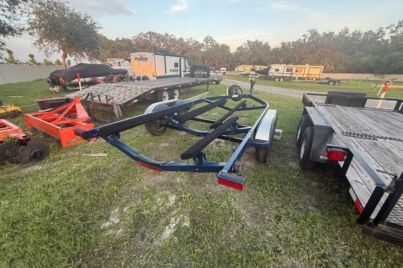 Slide: The Image of Trailer for 2014 Yamaha Boats 242 Limited S, parked outdoors with other equipment. - 56