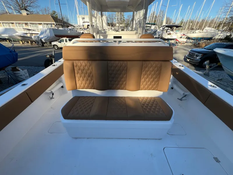 Slide: The Image of 2025 Invincible 33 Catamaran with tan leather seating in a marina. - 12