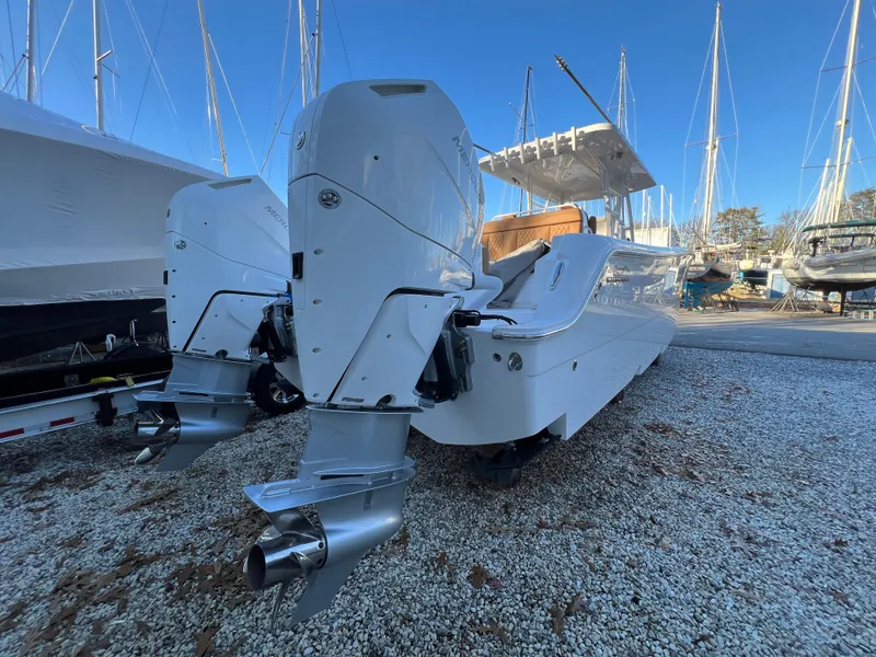 Slide: The Image of 2025 Invincible 33 Catamaran with twin outboard engines in a boatyard. - 4