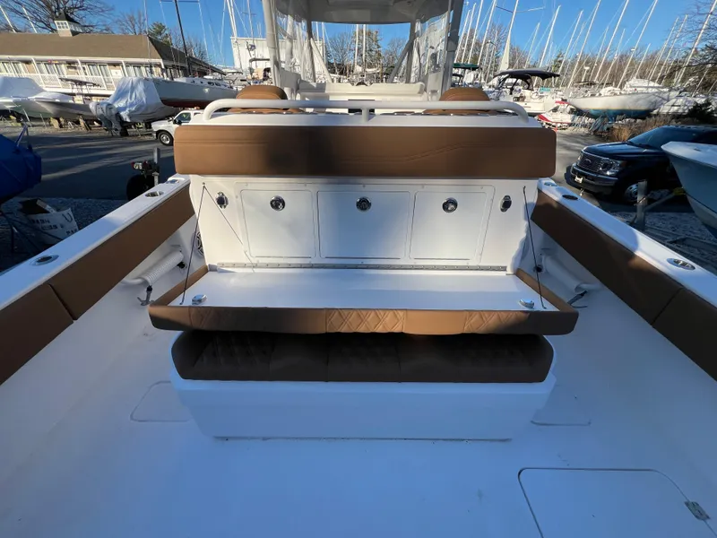 Slide: The Image of 2025 Invincible 33 Catamaran interior with brown and white seating and storage compartments. - 13