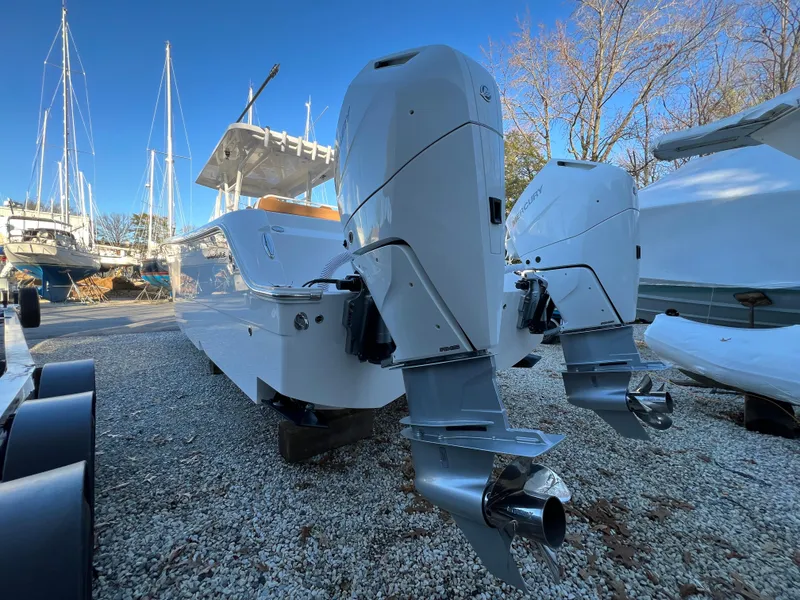 Slide: The Image of 2025 Invincible 33 Catamaran with dual outboard engines in a boatyard. - 3