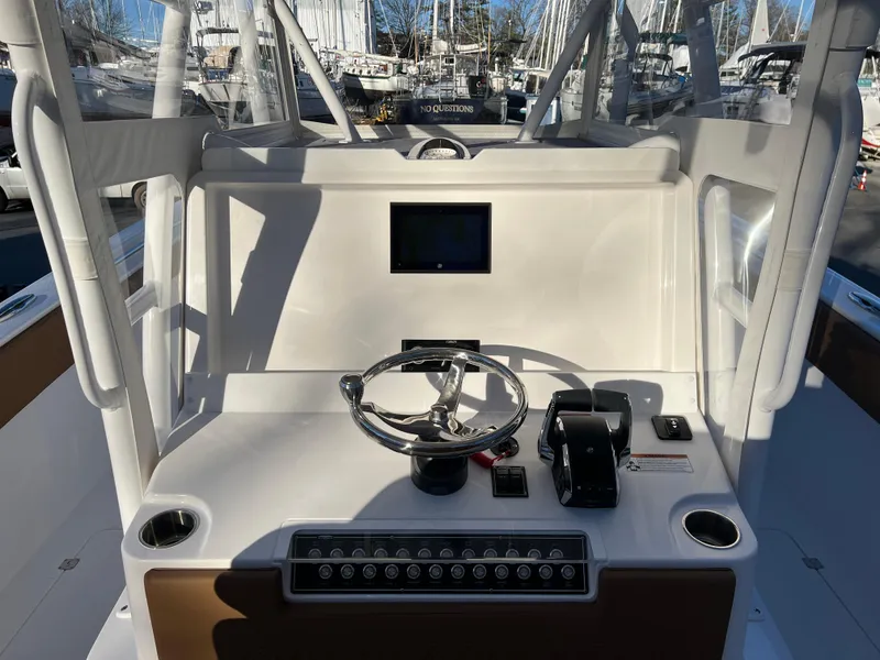Slide: The Image of 2025 Invincible 33 Catamaran helm station with steering wheel and control panel. - 10
