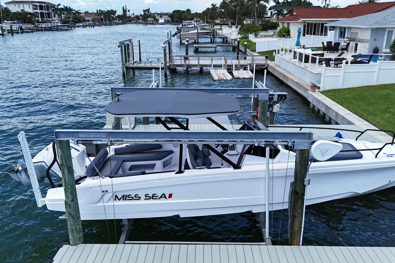 Slide: The Image of 2023 Axopar 25 Cross Top boat docked by waterfront homes. - 1