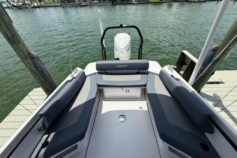 Slide: The Image of 2023 Axopar 25 Cross Top boat interior with seating, docked by the water. - 15